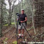 Photo of Michael Kahn with his camera and tripod in the woods